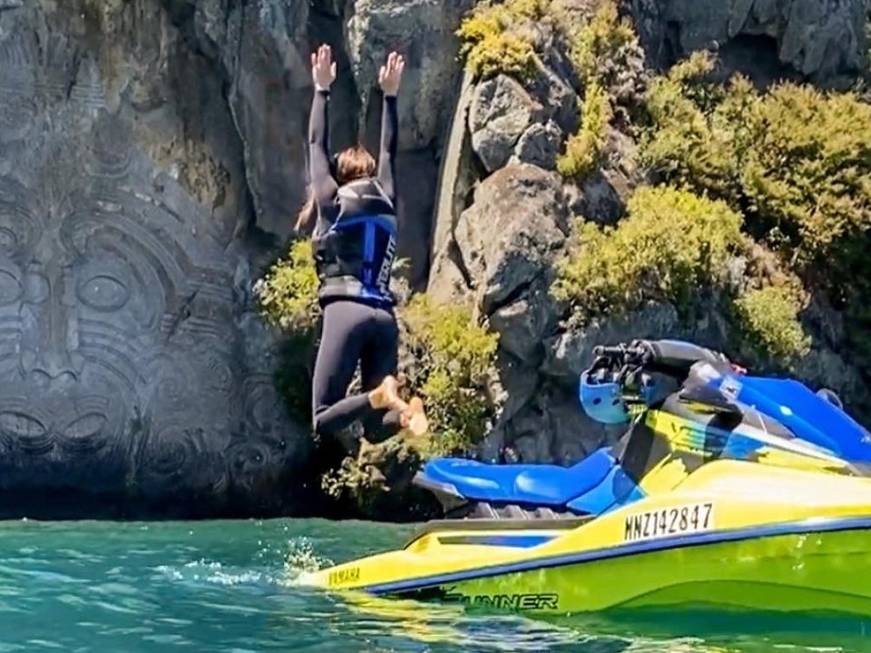 a group of people riding on the back of a boat in the water