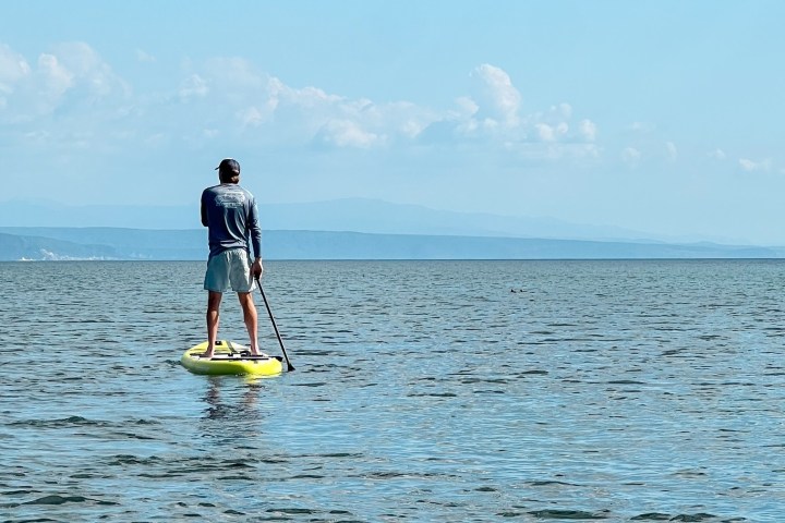 a man standing next to a body of water